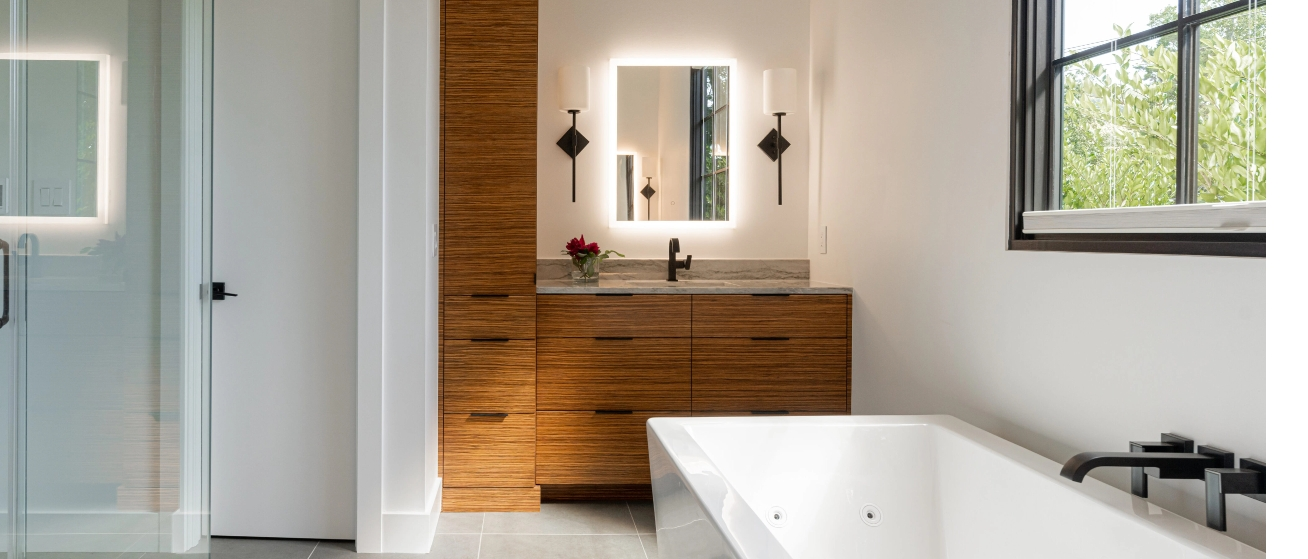 White Bathroom with wooden cabinets and a glowing mirror