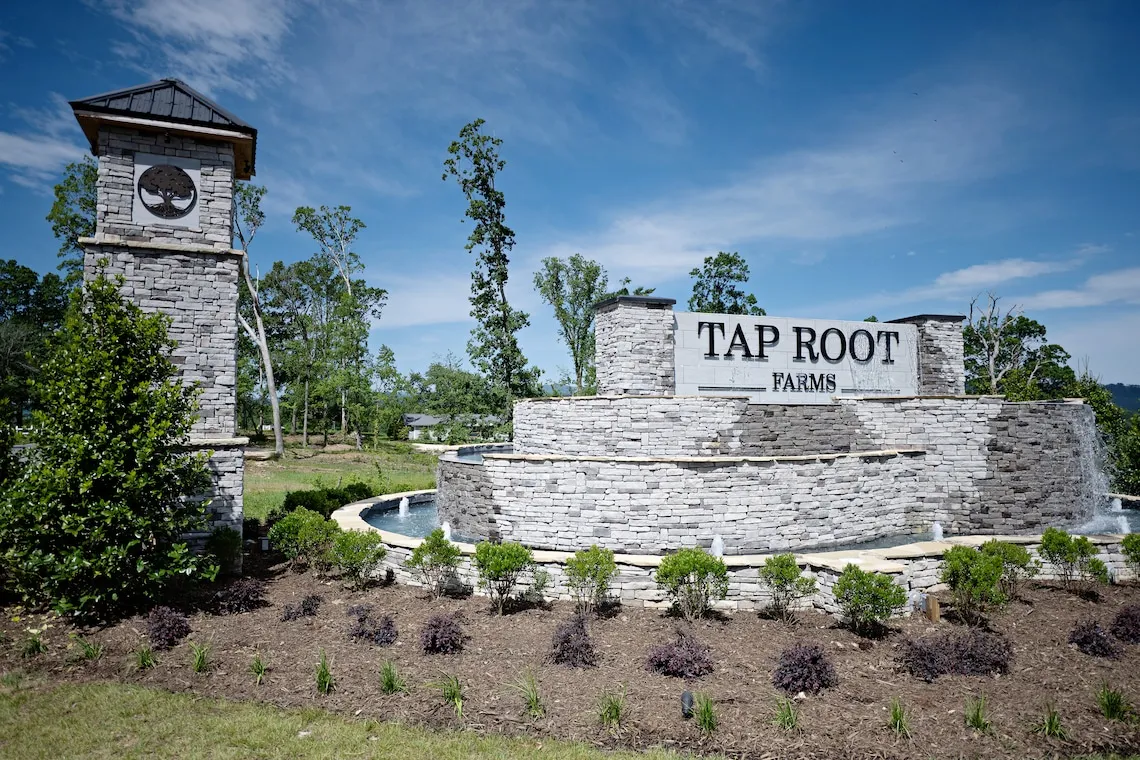 Tap Root Farms entrance sign with stone wall and fountain