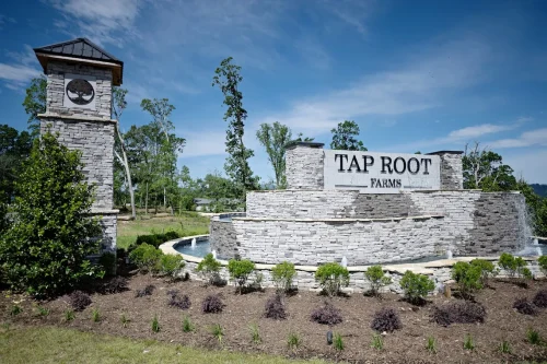 Tap Root Farms entrance sign with stone wall and fountain