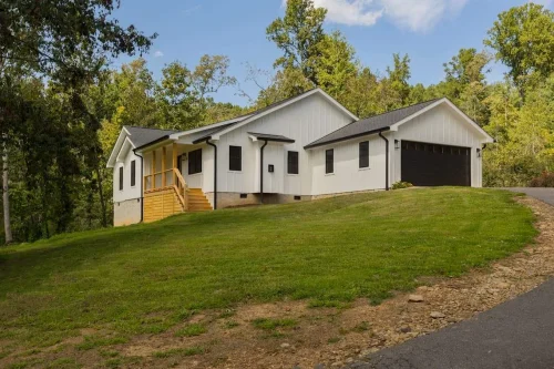 White modern farmhouse with black trim and attached two-car garage.