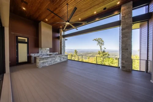 Spacious covered deck with a wood ceiling, stone columns, outdoor counter, and panoramic mountain views.