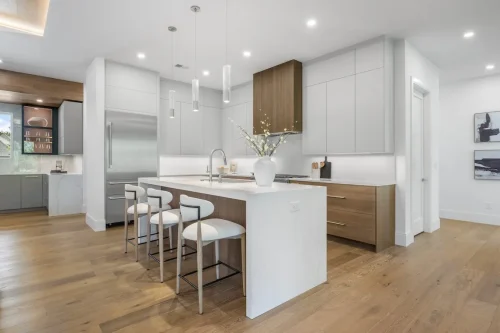 Bright kitchen with white countertops, pendant lights, and wood cabinets.