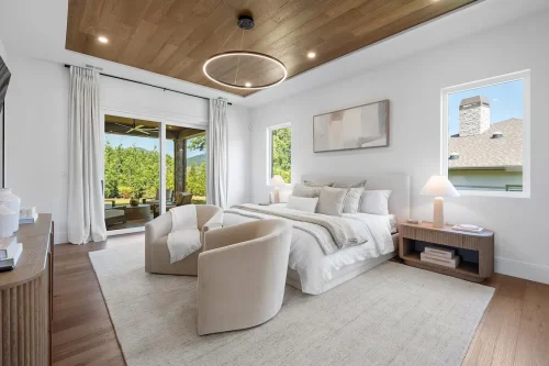 Bedroom with neutral tones, wood ceiling, and large sliding doors to patio.