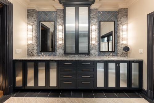 The Phoenix House dramatic dark vanity with double sinks and mirrors with blue tile wall.