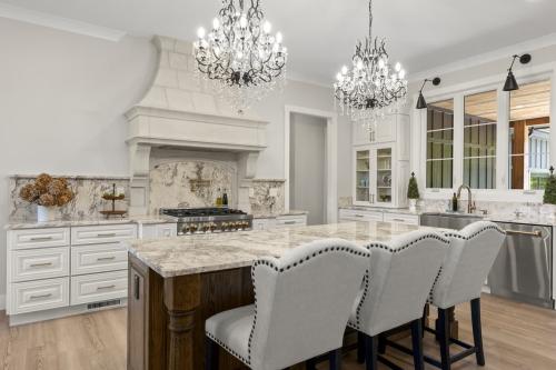 Benton Farms white kitchen with two chandeliers.