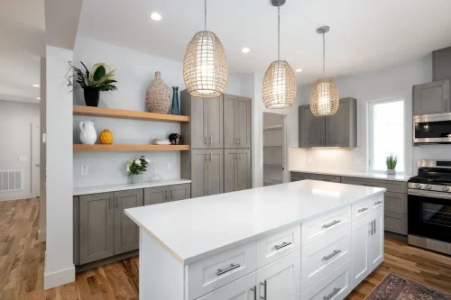 Kitchen island with breakfast bar, wicker pendant lights, and wood stools.