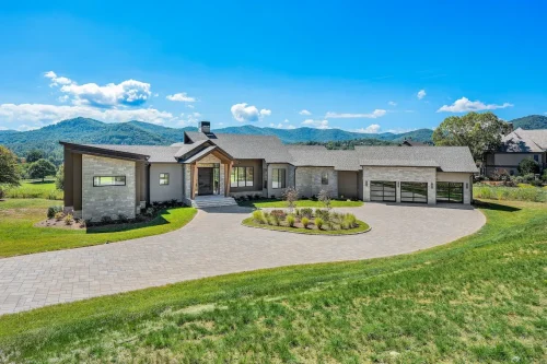 Modern mountain home with clean lines, stone accents, and a circular paver driveway set against Blue Ridge views.