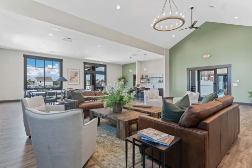 Open clubhouse seating area with green accent wall and large windows