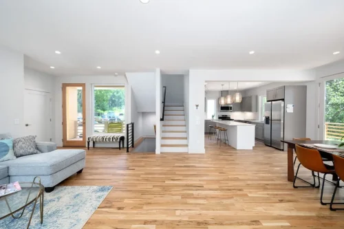 View from living room showing stairs, kitchen with island, and open airy floor plan.
