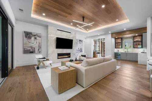 Living room with light wood ceiling, modern fireplace, and built-in bar.