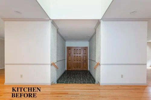 Interior before renovation showing white walls, hardwood floors, a tiled entryway, and wood double doors.