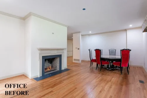 Office before renovation featuring a traditional fireplace, hardwood floors, white walls, and a dining table with red upholstered chairs.