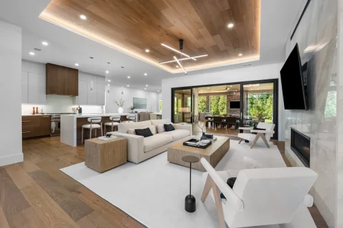 Open-concept living area with kitchen, large windows, and neutral decor.