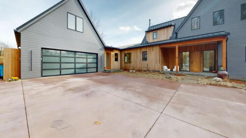 Arcadian Abode exterior blue and wood with large detached garage.