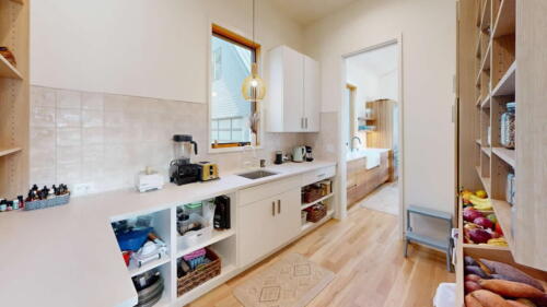 Arcadian Abode pantry with white cabinets, and shelves with lots of storage.