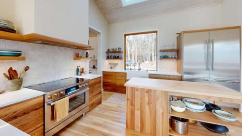 Arcadian Abode modern kitchen with wood island, and wood cabinets.