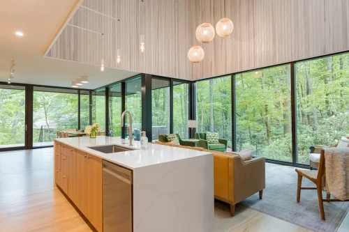 Kitchen island with marble countertop and forest view.