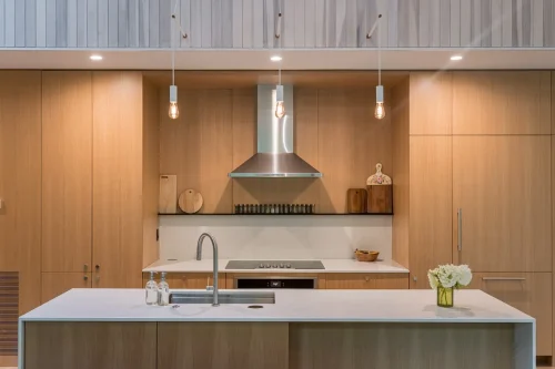 Close-up of wood-paneled kitchen with stainless range hood.