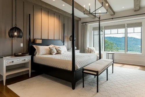 Cozy bedroom with a black canopy bed, neutral decor, and mountain views.