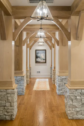 Hallway with stone columns, wood beams, and pendant lighting.