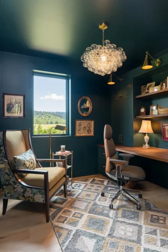 Home office with dark walls, wood desk, patterned rug, and bubble chandelier.