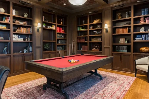 Home library with built-in bookshelves and a red felt pool table.