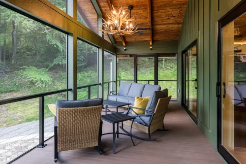 Screened porch with wicker seating and antler chandelier.
