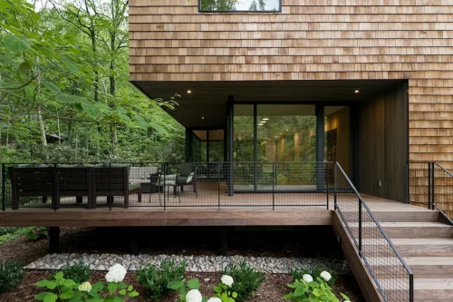 Outdoor deck with seating surrounded by trees.
