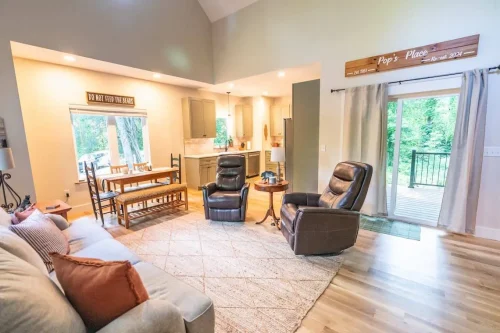 Inviting living space with dining area, kitchen, recliners, and sliding glass doors opening to a back porch.