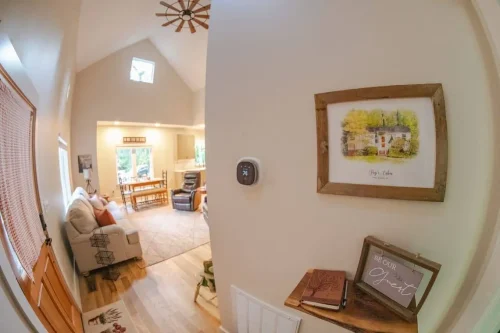 Entry hall with farmhouse décor and artwork leading into the vaulted living and dining space beyond.