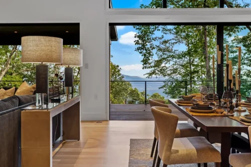 Elegant dining room opening onto a deck with sweeping Blue Ridge Mountain views through floor-to-ceiling windows.