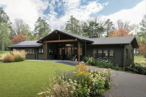 Dark-sided home with a covered front porch, wood accents, and landscaped gardens.