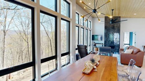The Modern Tree House living room/dining room with wall of wall to ceiling windows.