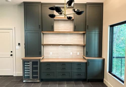 Inside of the Tulip Poplar home; WNC Parade of Homes; Modern Home view of downstairs living space; Built in storage cabinets; wine cooler; entrance to garage.