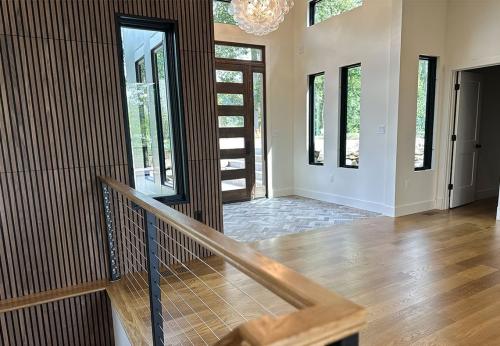 Inside of the Tulip Poplar home; WNC Parade of Homes; Modern Home view of main entrance to the home; Herringbone brickwork, modern lighting fixture, tall front door
