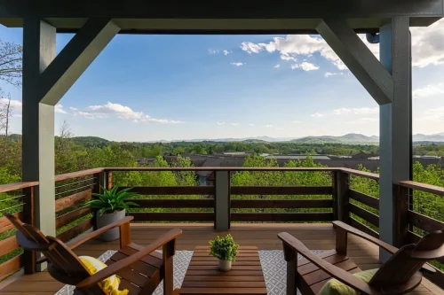 Covered wood deck with seating overlooking rolling hills and distant mountains.