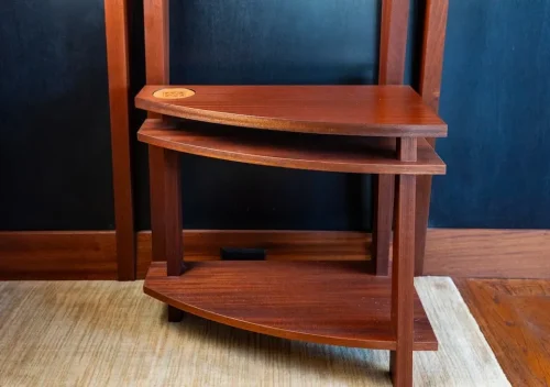 Wood side table with curved shelves and handcrafted detailing.