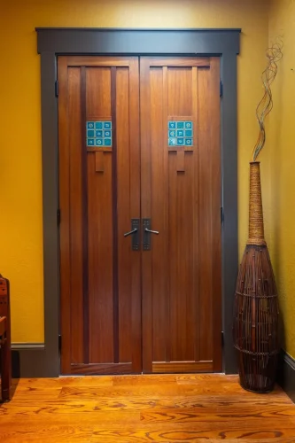 Double wood doors with vertical paneling and blue-green decorative tile accents.