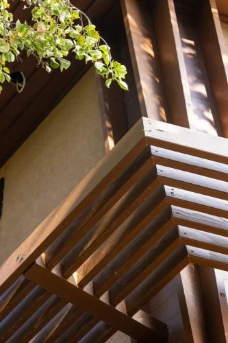 1. Close-up of wood architectural detailing and horizontal slats beneath a roof overhang.