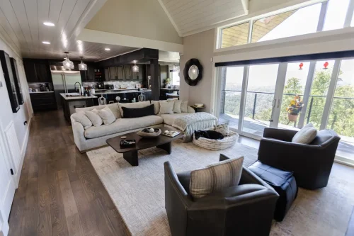 Living room with large windows, beige sofa, and mountain view.