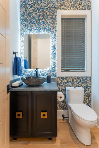 Powder room with round glass pieces on the wall.