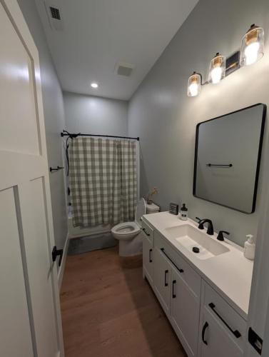 Custom Barndominium white bathroom with wood floor.