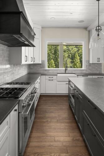 Kitchen with charcoal island, and white cabinets.