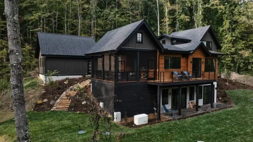 Screened-in porch with vaulted ceiling, comfortable seating, and wooded views, designed for indoor-outdoor living.