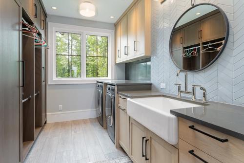 Rustic Mountain Estate laundry room with sink, cabinets, closets and washer/dryer.