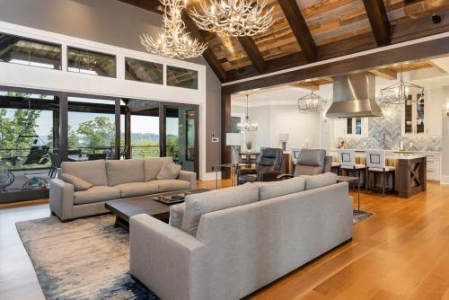 Rustic Mountain Estate view of living room / kitchen. Living room has two antler chandeliers.