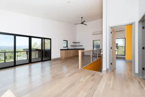 Modern detached garage with apartment above, featuring black framed windows and a clean architectural design.